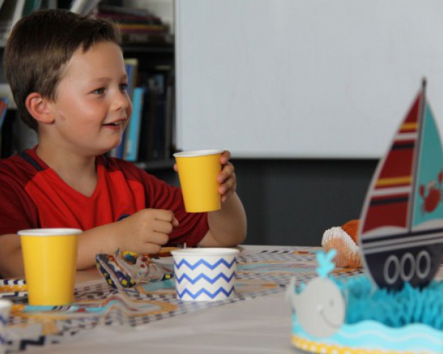 enfant avec gobelet fêtant son anniversaire